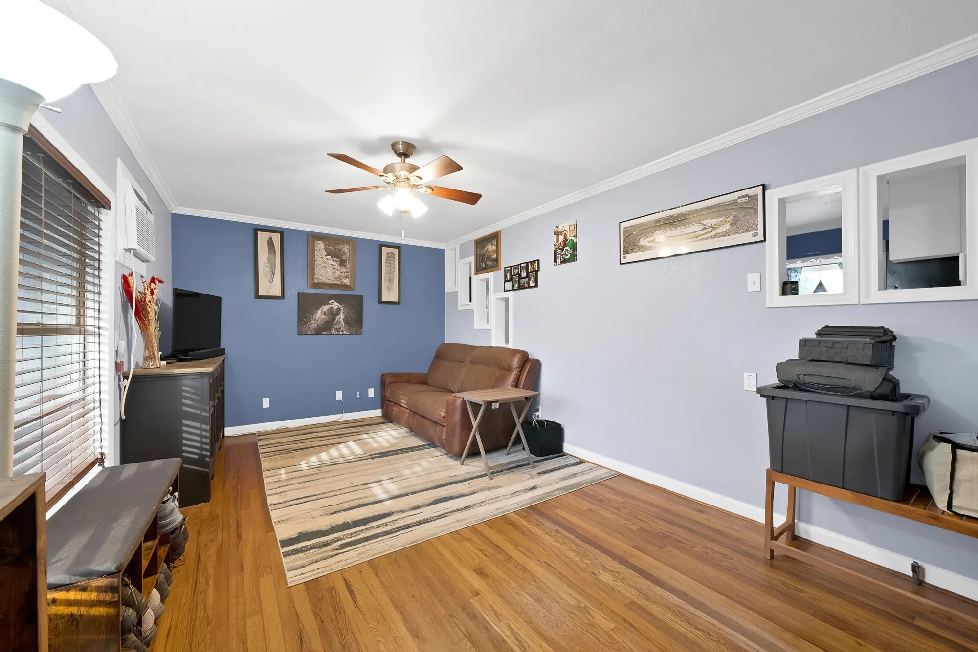 Hardwood-finish flooring, ceiling fan, crown molding, and window blinds
