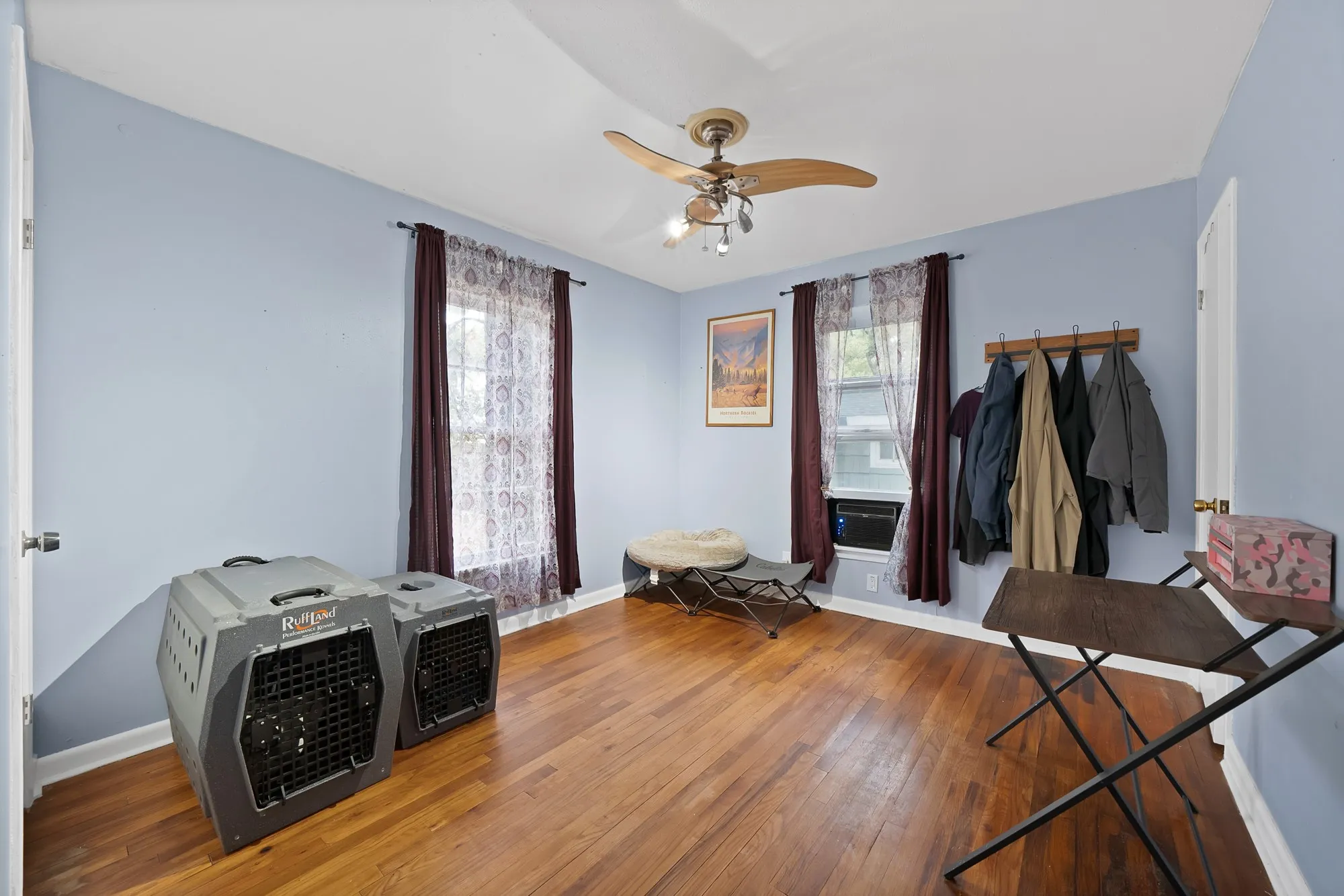Hardwood flooring, light blue wall paint, and a ceiling fan with integrated lighting
