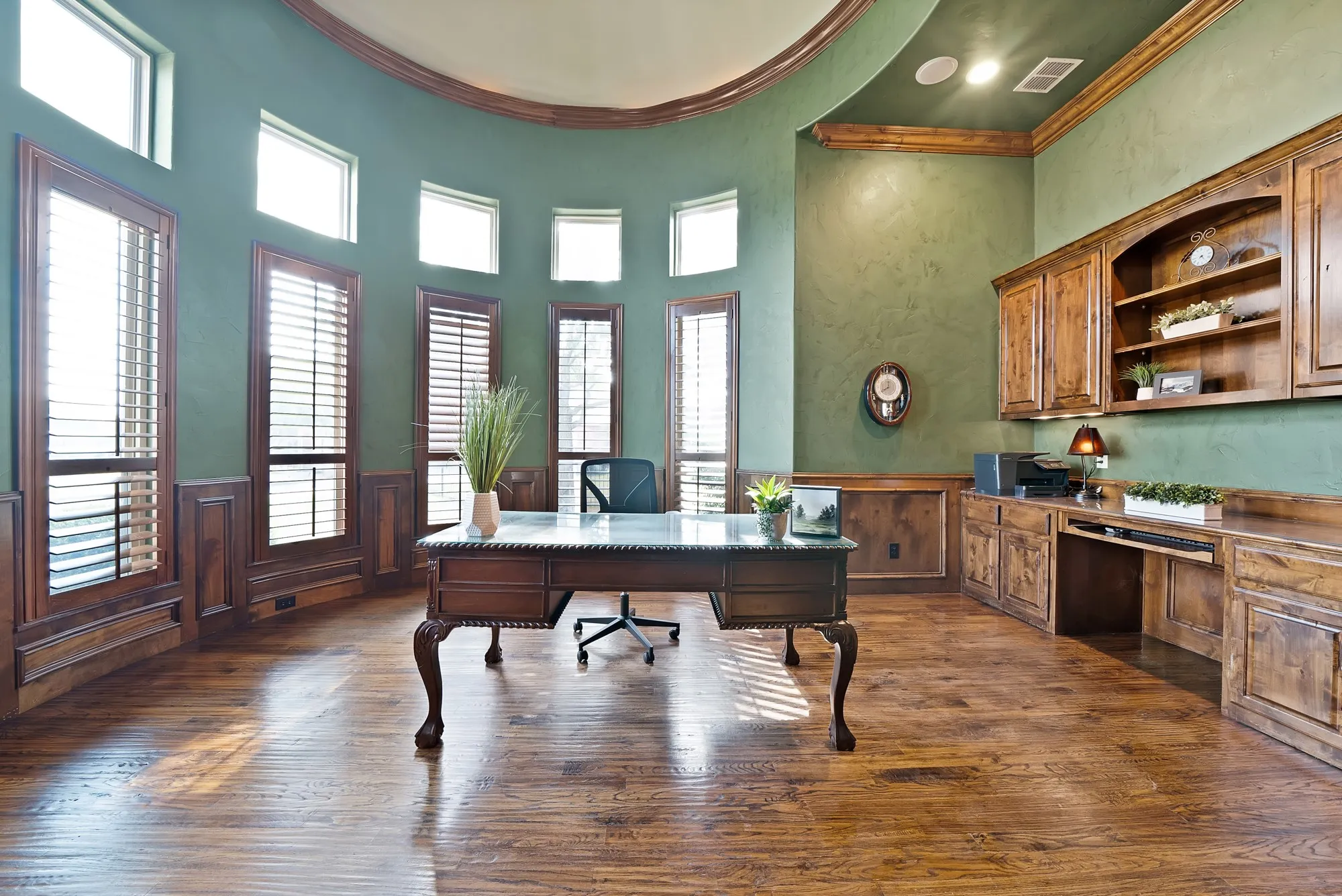 hand scraped hardwood floors throughout, featuring a curved wall with multiple windows and wood plantation shutters