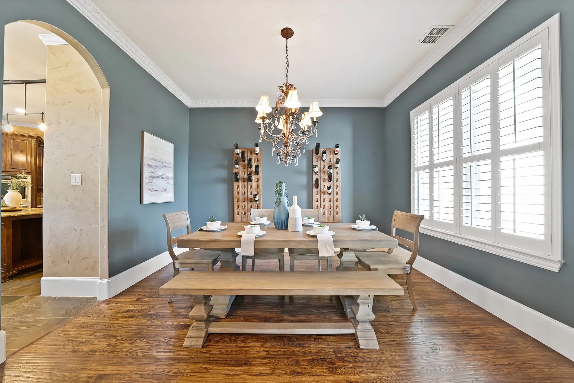hand scraped hardwood floors, crisp white crown molding, and a decorative chandelier