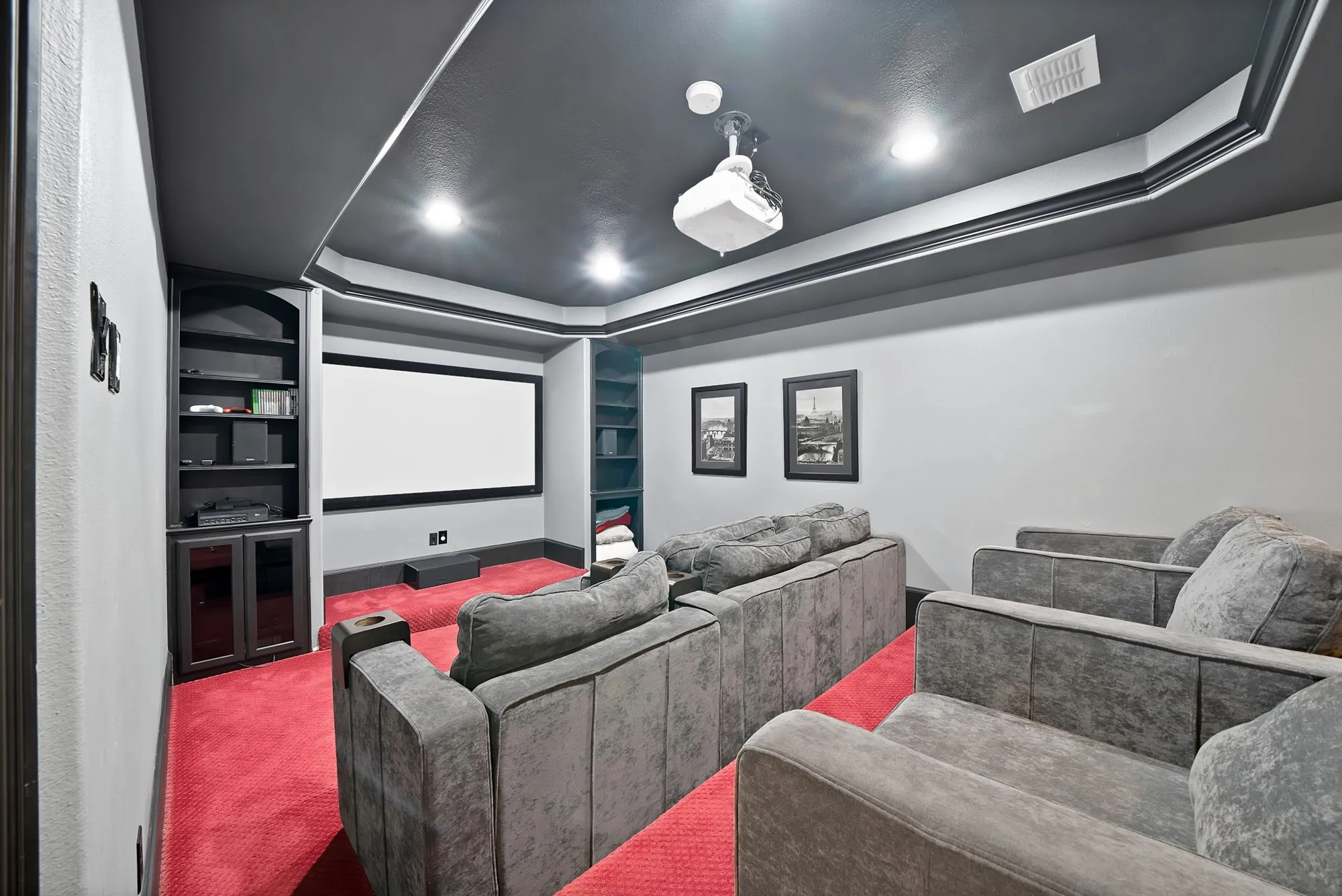 Theater room featuring a projection screen, built-in shelving, recessed lighting, and a dark-painted ceiling with crown molding
