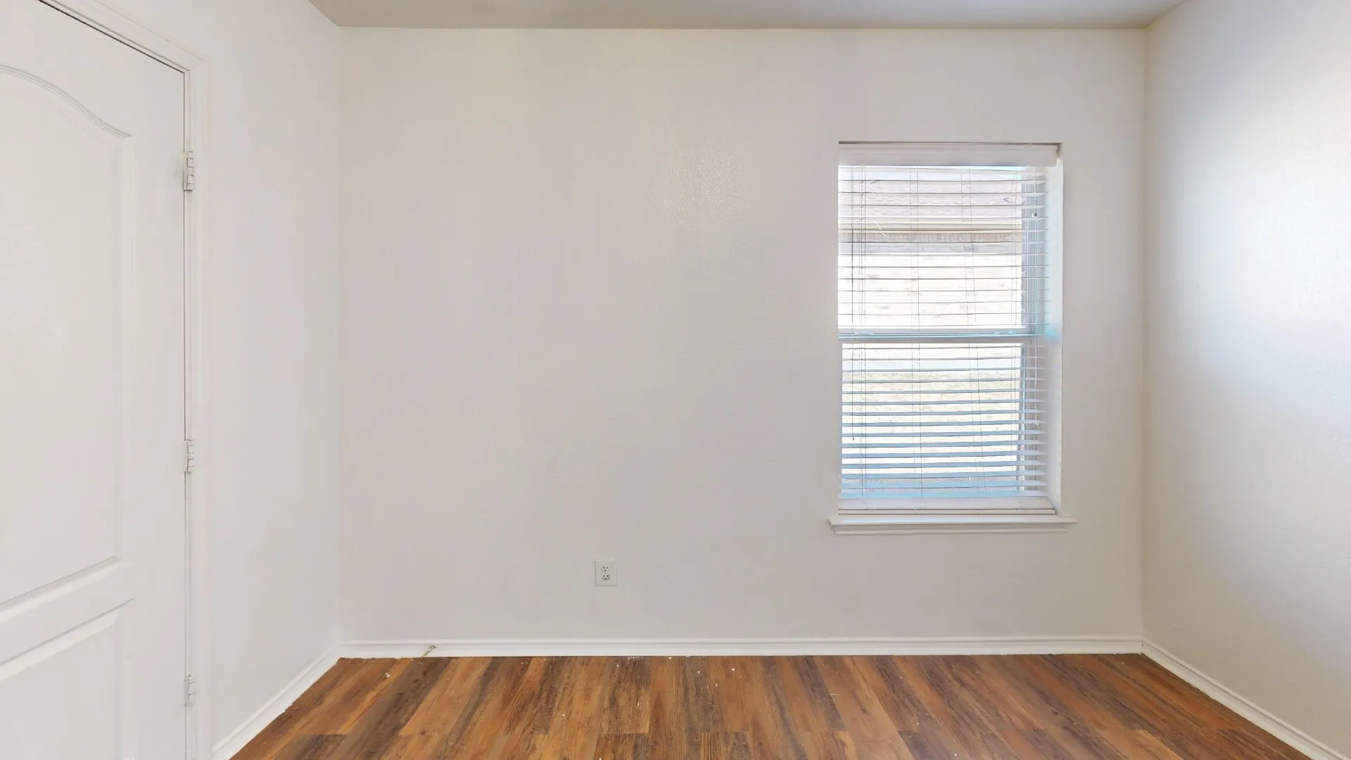 Wood-finish flooring with white baseboards
