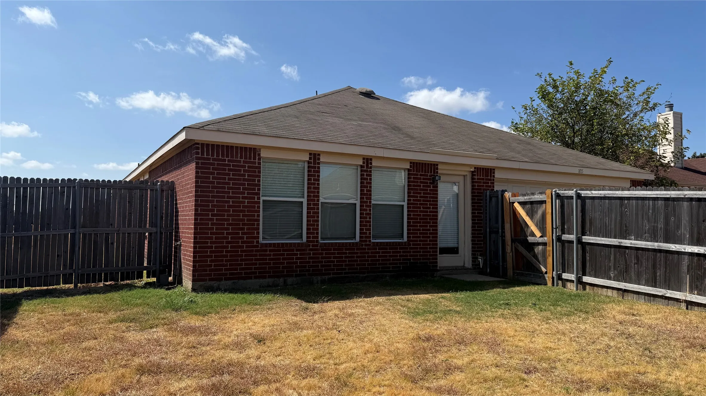 Brick exterior with a partial fenced yard and a single entry door