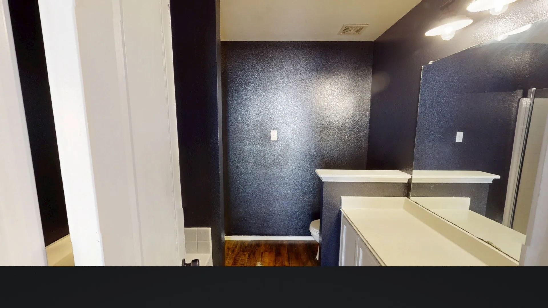 White vanity with a neutral-toned countertop and an integrated sink
