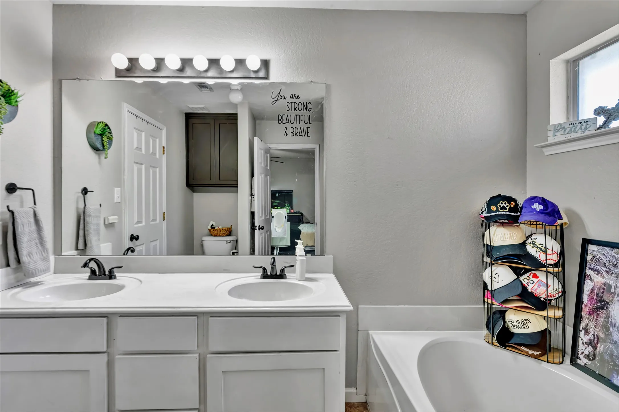 Dual vanity with integrated sinks, dark bronze fixtures, and overhead bar lighting