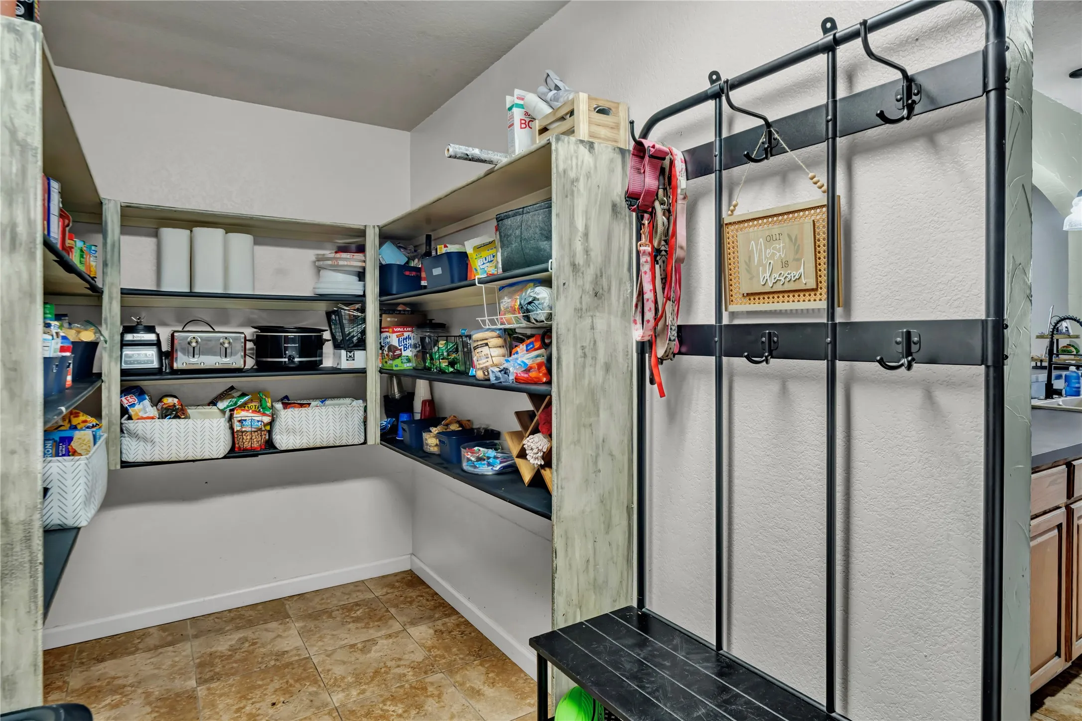 Built-in shelving for organized storage, tile flooring, and a wall-mounted coat rack
