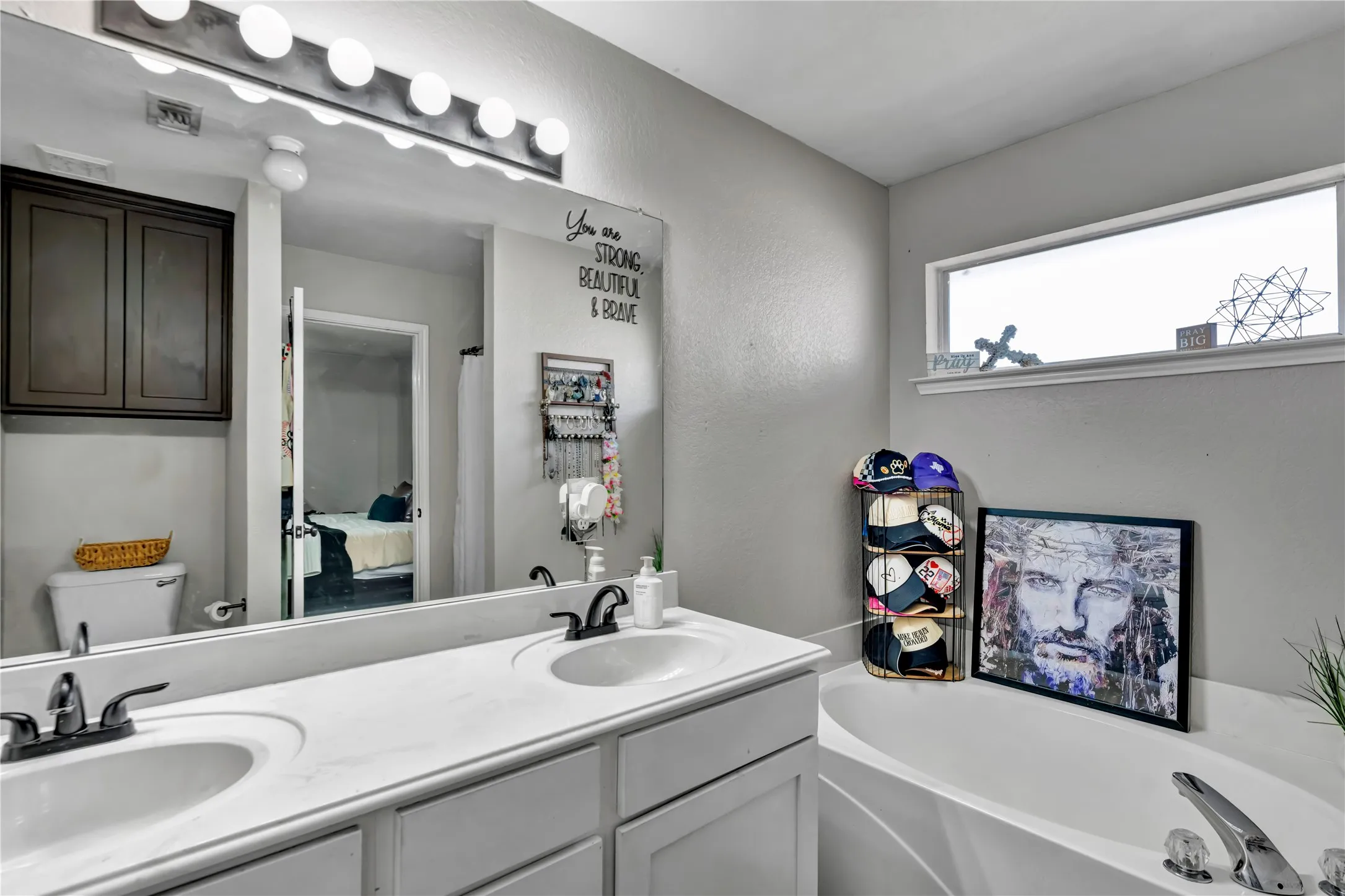 Double vanity with integrated sinks, white countertops, and dark bronze faucets
