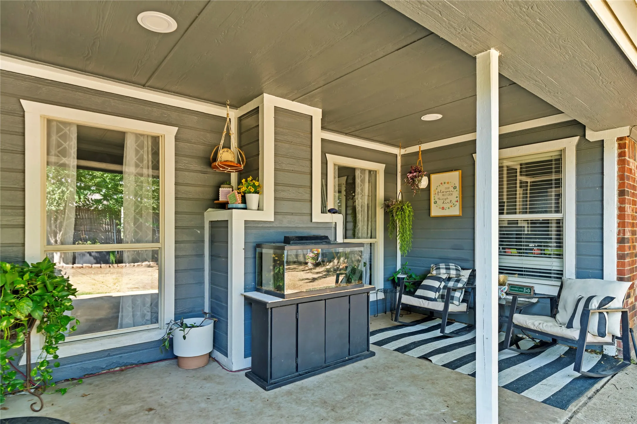 Covered outdoor patio with a concrete surface, gray siding, white trim, and recessed lighting