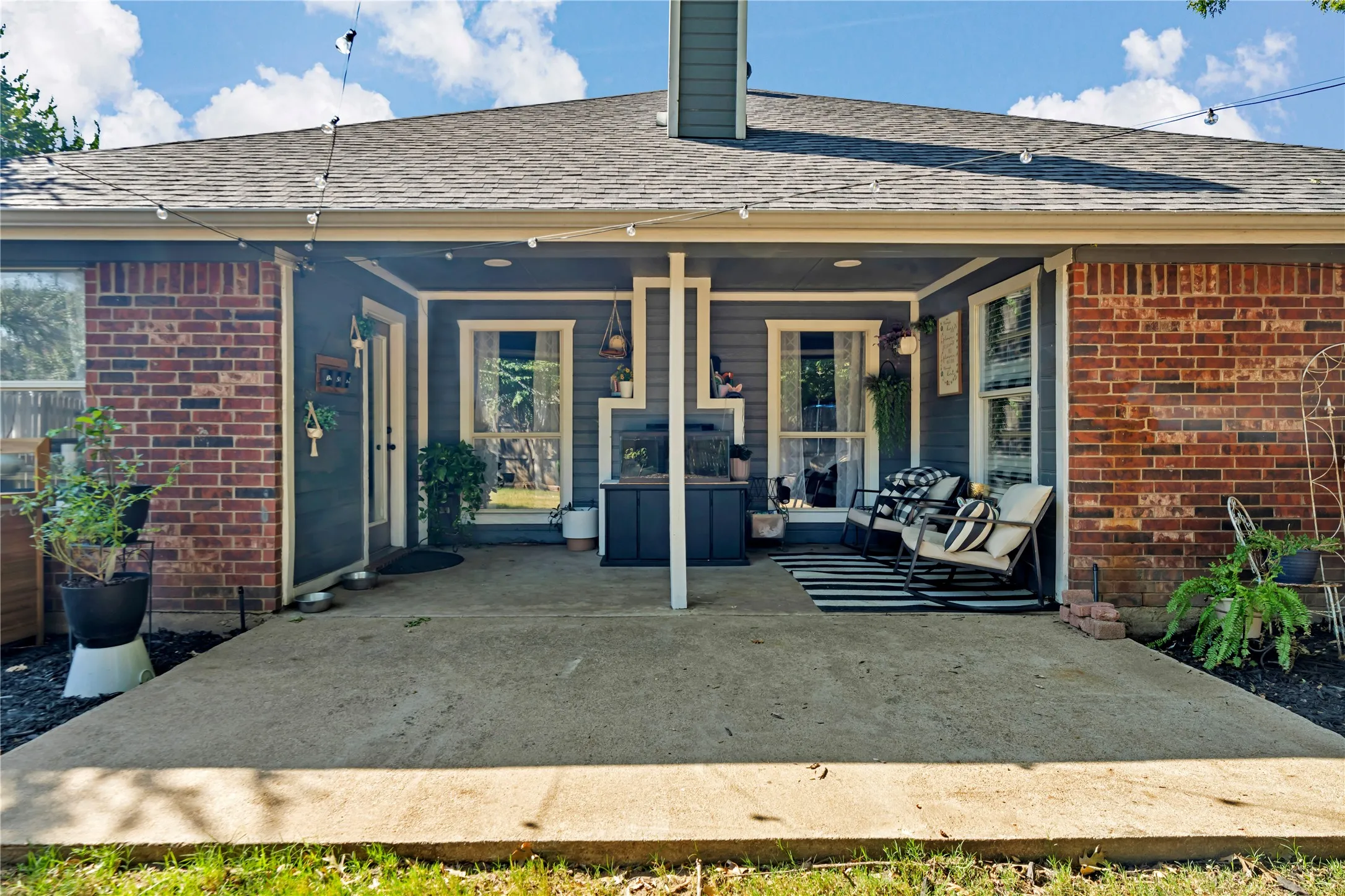 Covered patio featuring a concrete slab and brick exterior