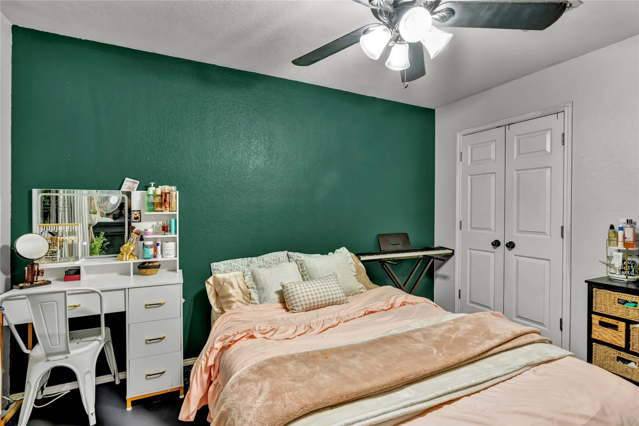 Ceiling fan with integrated lighting, paneled closet doors, and dark accent wall
