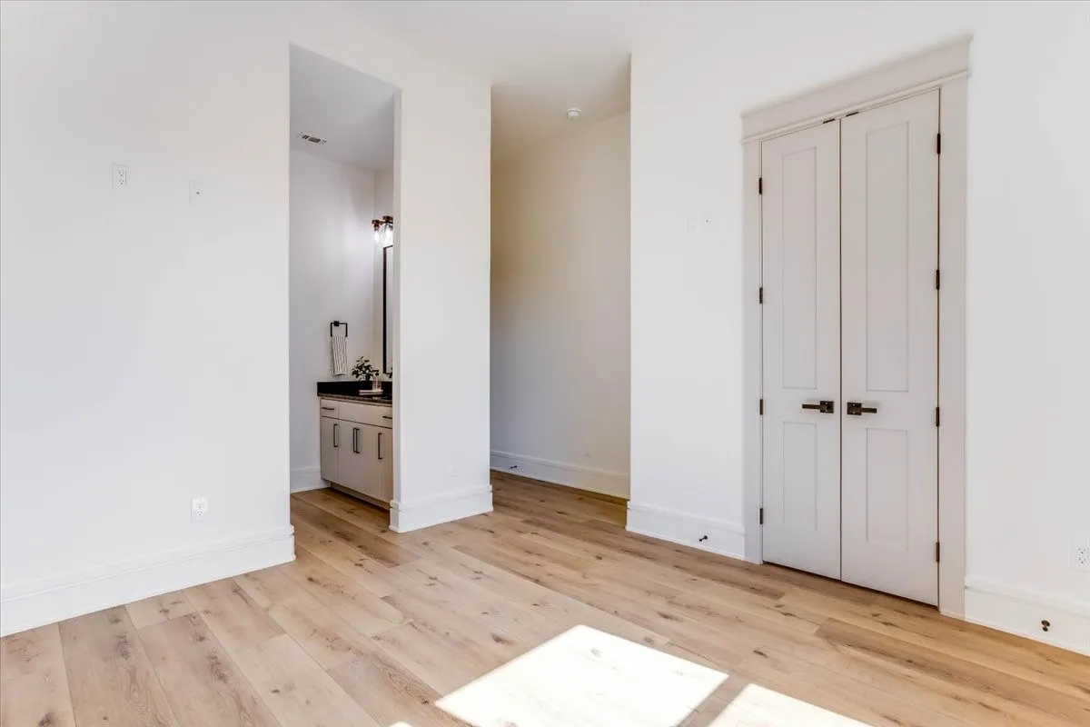LVP flooring, custom baseboards, and bi-fold doors with dark hardware