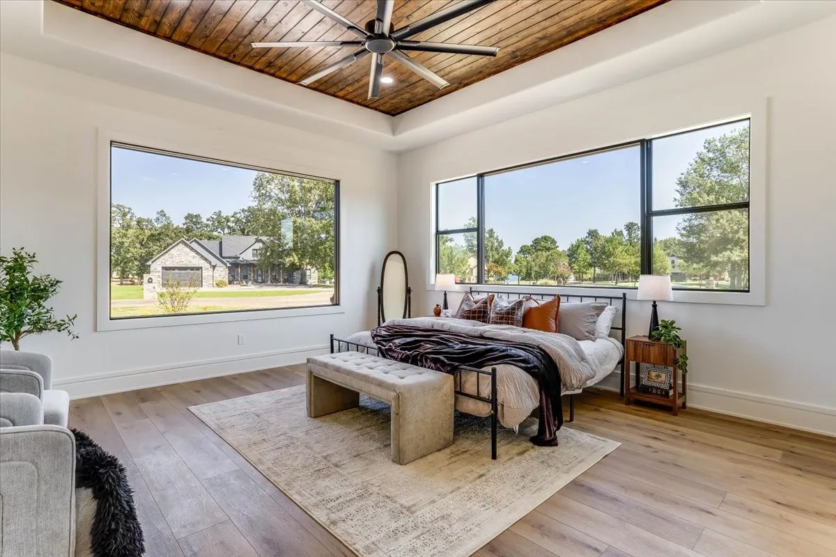 Wood-finish flooring, white walls, and a wood-ceiling with a ceiling fan