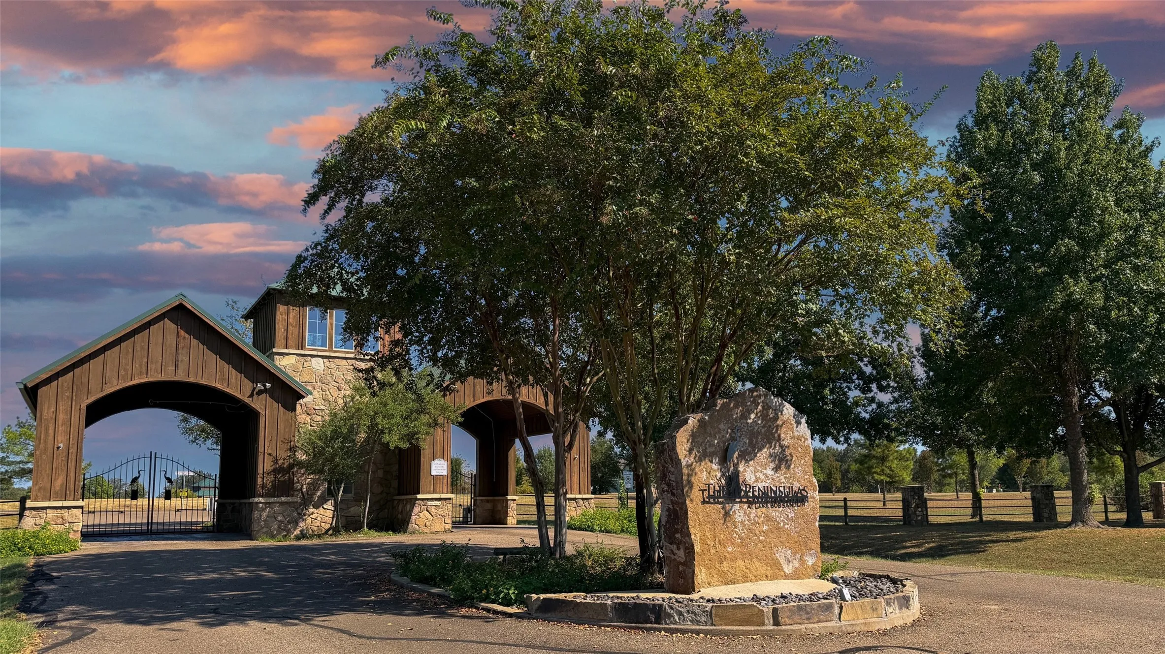 Stone and wood-clad entryway with a gabled roof and decorative metal gates