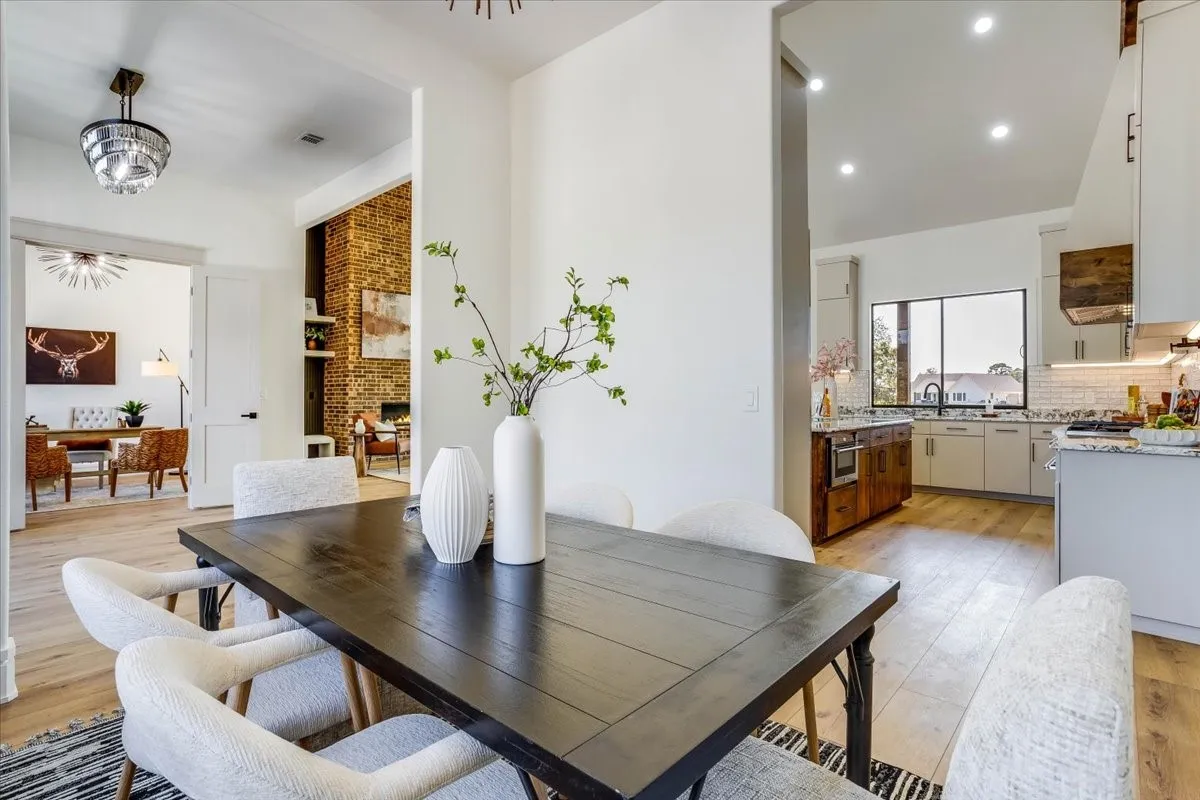 Open concept living area with LVP flooring, recessed lighting, and a kitchen featuring a tile backsplash and under-cabinet lighting