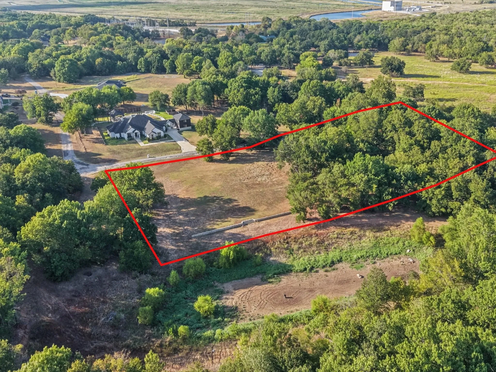 Expansive lot featuring a mix of open land and mature trees
