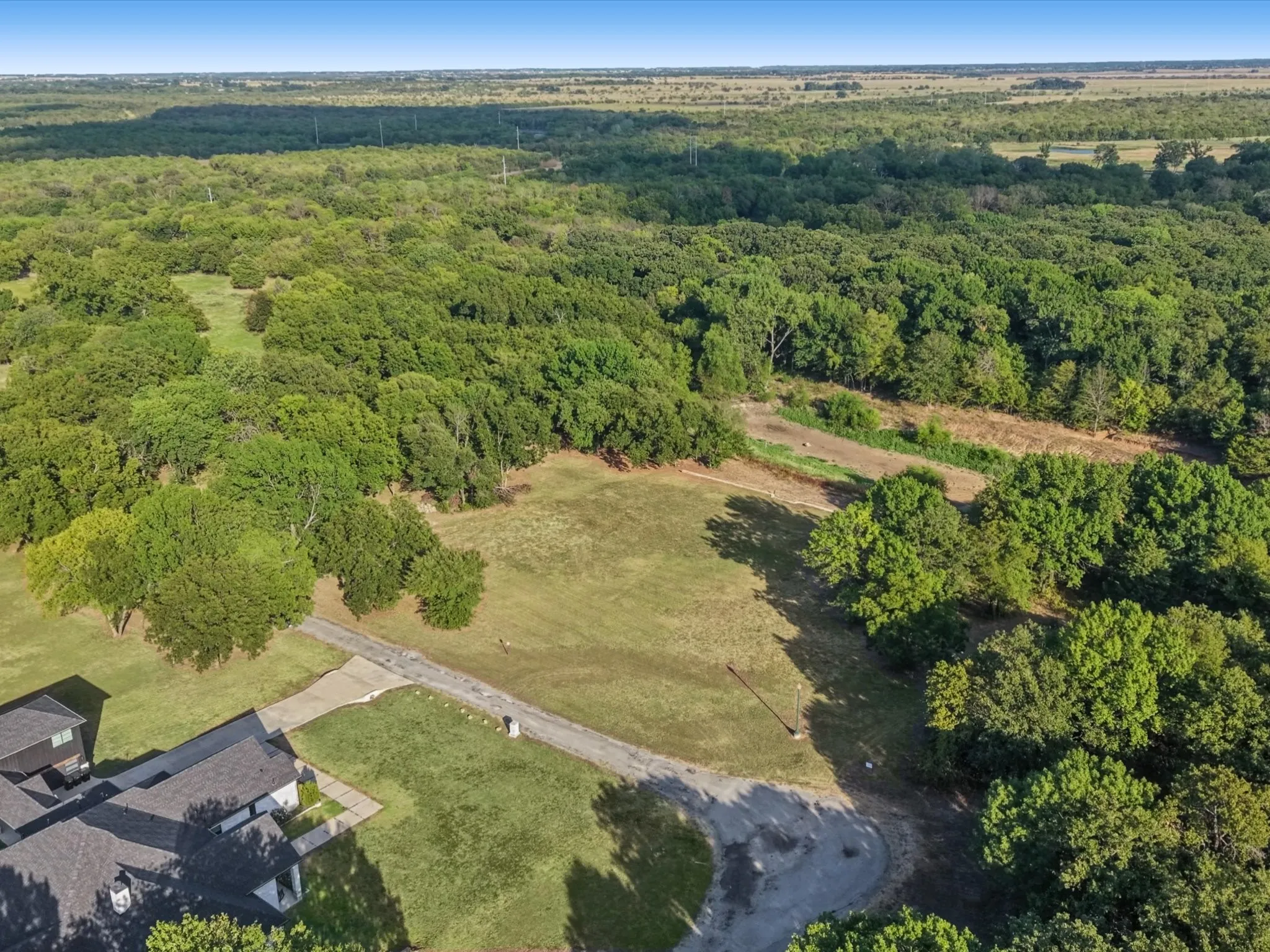 Expansive lot featuring mature trees and a paved driveway
