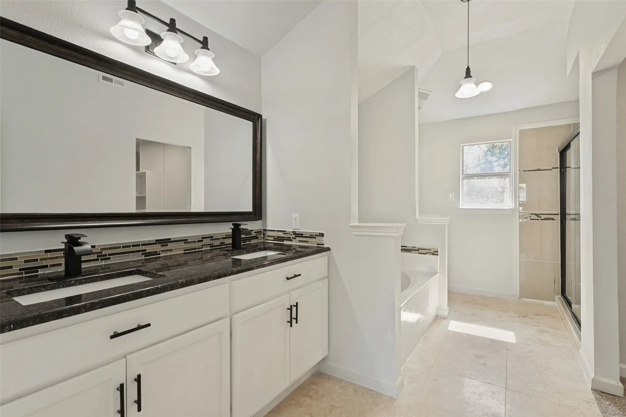Dual vanity with dark countertops and matte black fixtures