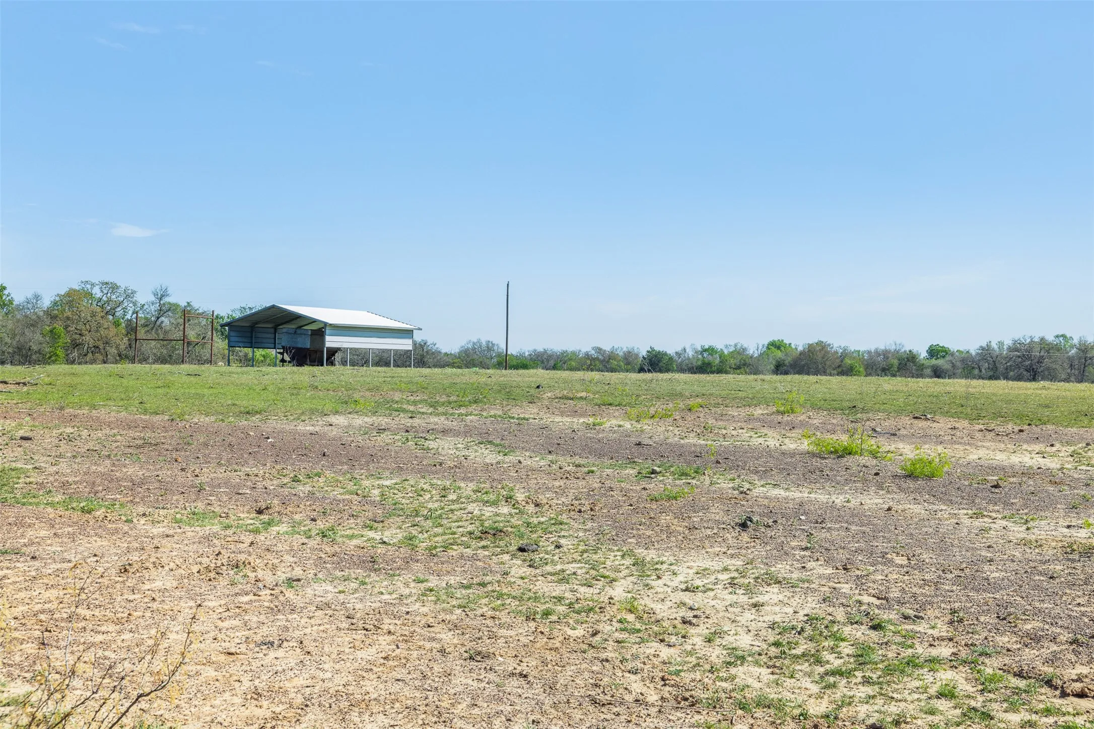 Expansive open field with a metal-roofed barn structure