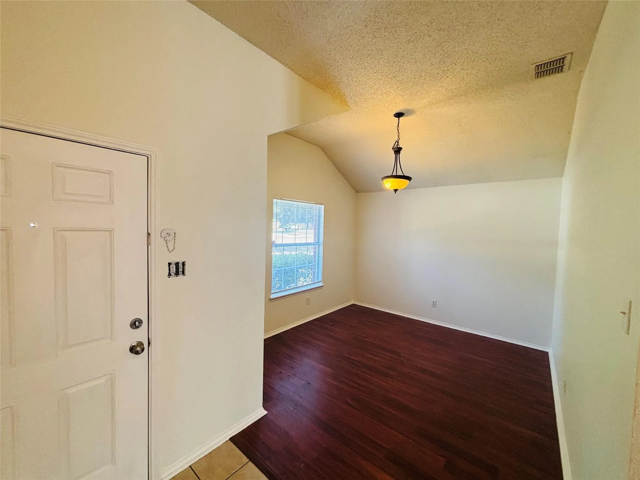 Entry foyer featuring a paneled door, ceramic tile flooring, and a recessed archway