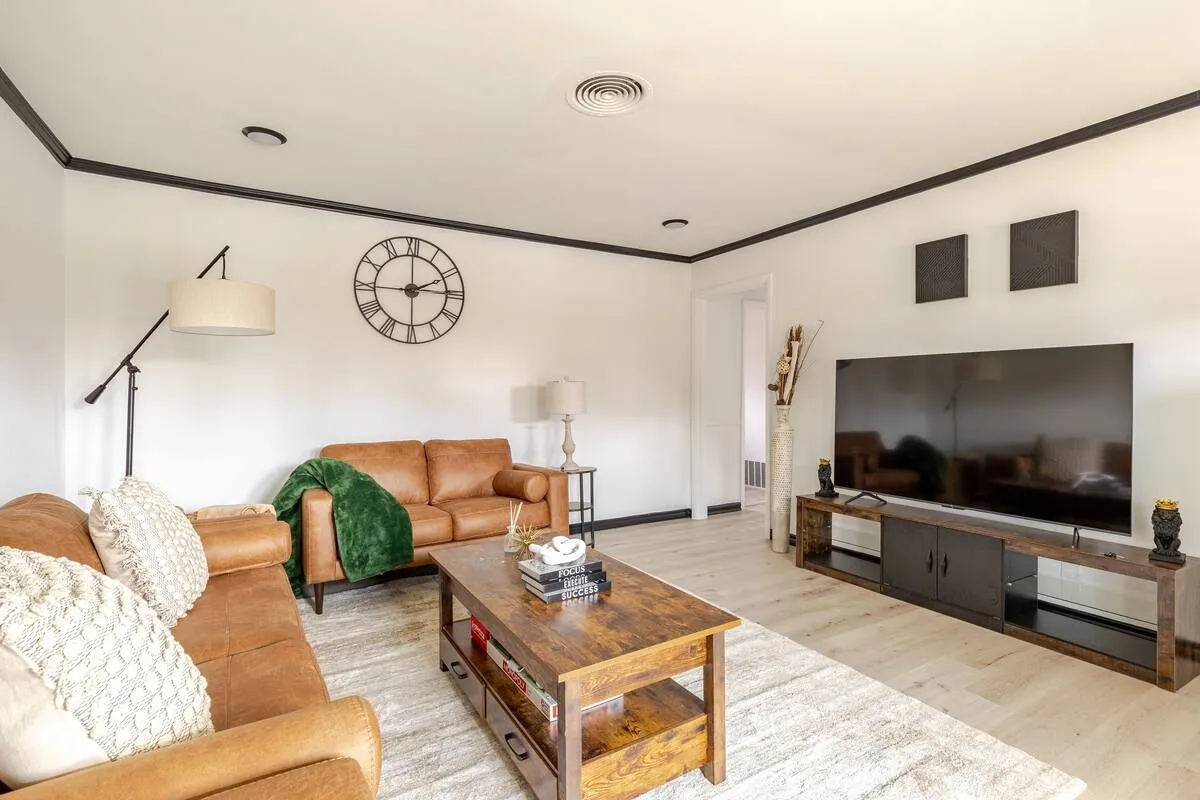 Light wood-finish flooring with white walls and dark trim