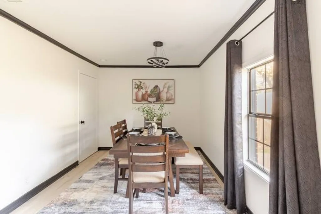 White walls with contrasting dark trim, wood-finish flooring, a contemporary chandelier, and a window with grid detailing