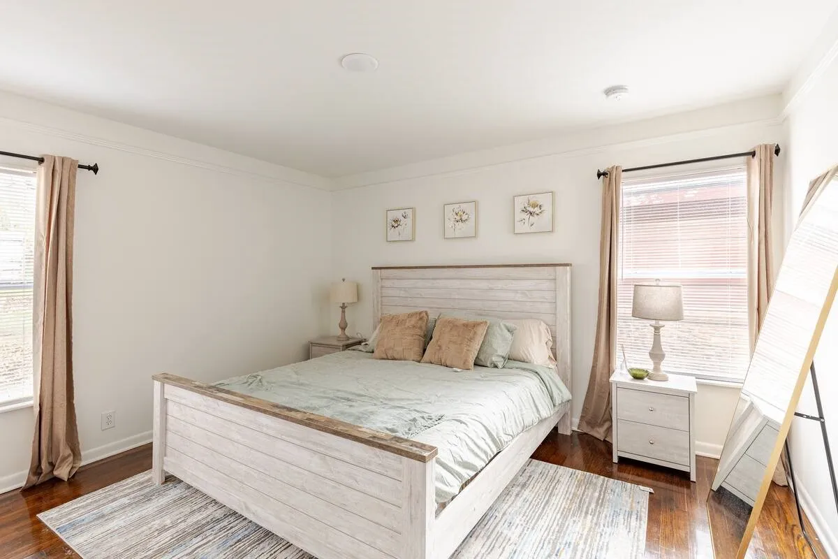 Hardwood flooring, recessed ceiling lighting, crown molding, and two windows with blinds