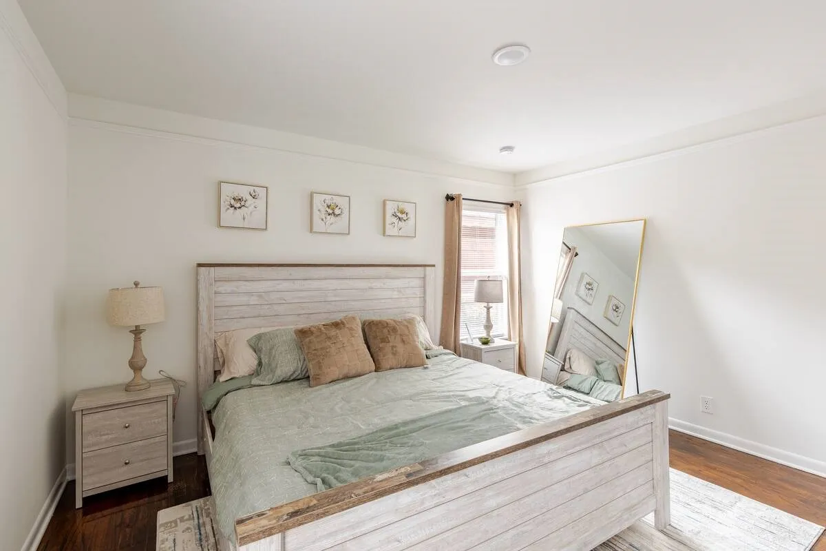 Recessed ceiling lighting, crown molding, wood-finish flooring, and natural light from a window with drapes