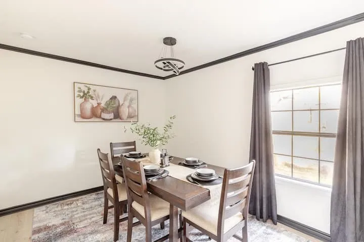 Dining area featuring crown molding, a decorative chandelier, and a multi-pane window