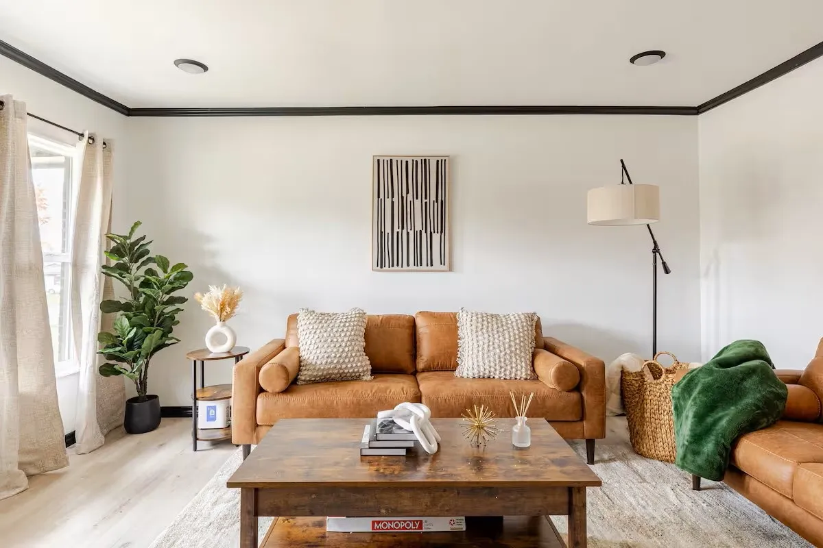Light wood-finish flooring, recessed ceiling lighting, crown molding, and a large window