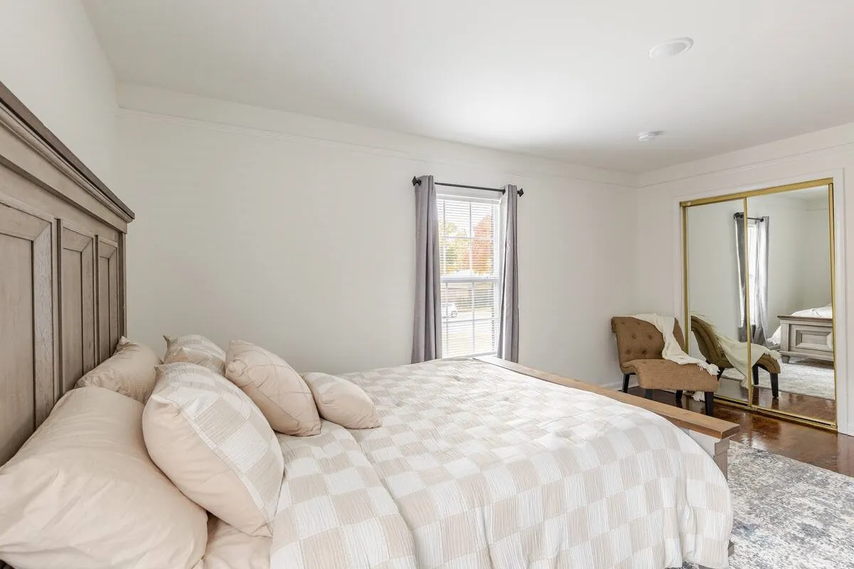 Crown molding, recessed lighting, wood-finish flooring, and mirrored closet doors