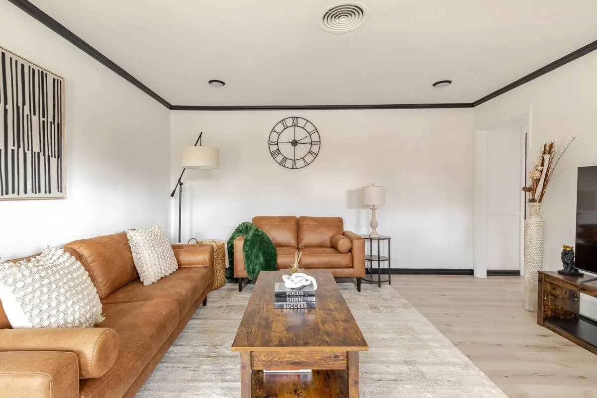 Wood-finish flooring, recessed lighting, crown molding, and a solid-panel door