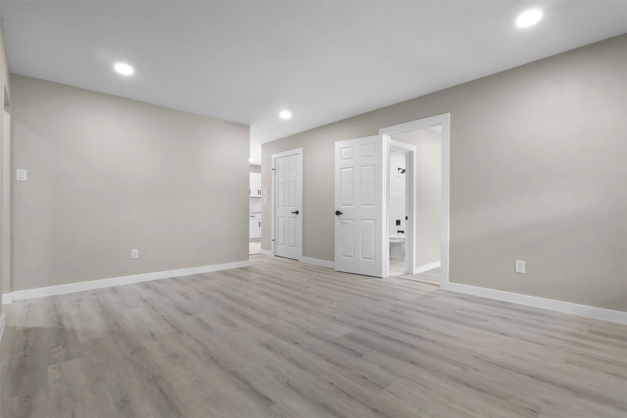 Spacious room with wood-finish flooring, recessed lighting, and neutral wall paint