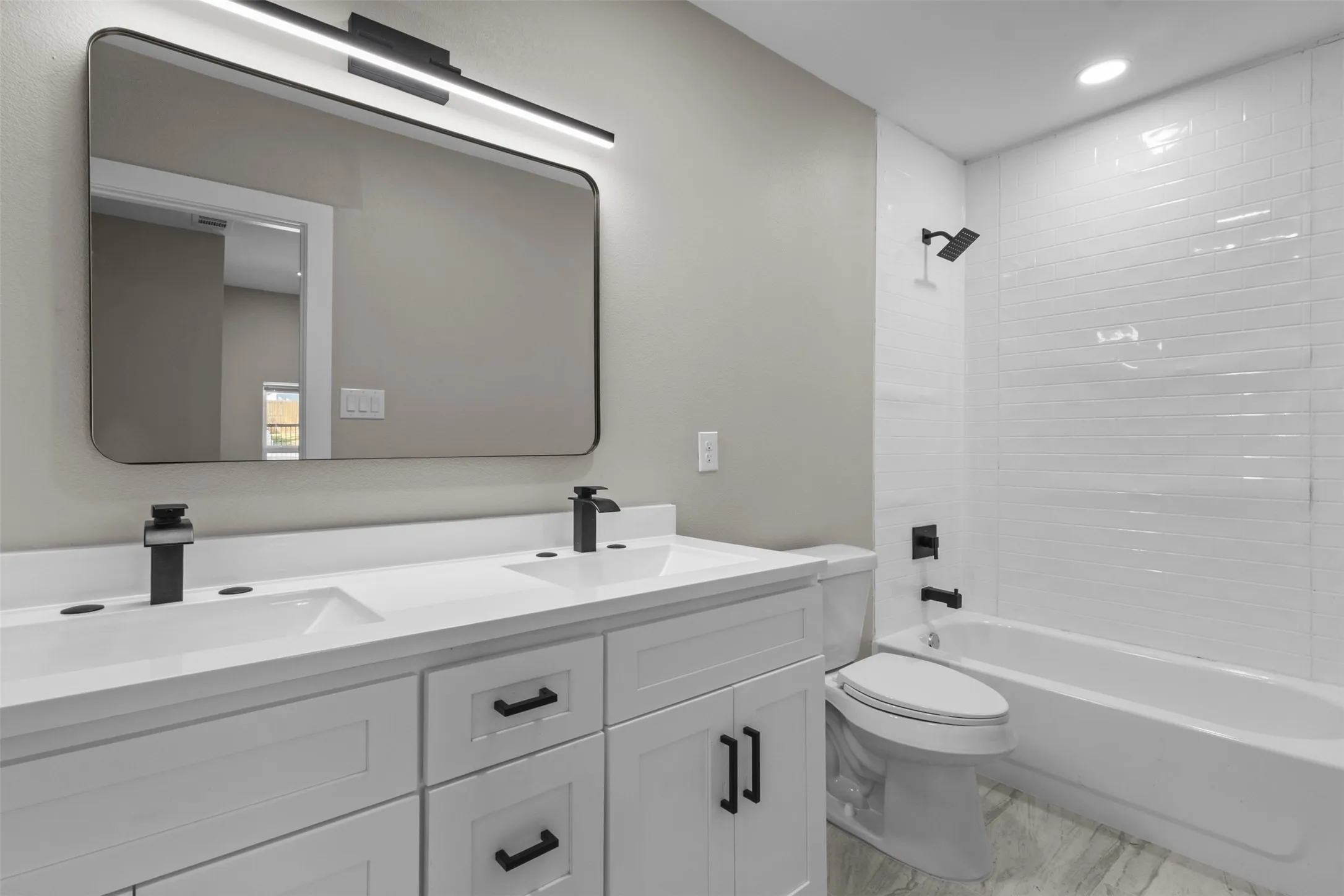 Double vanity with white cabinetry and matte black hardware