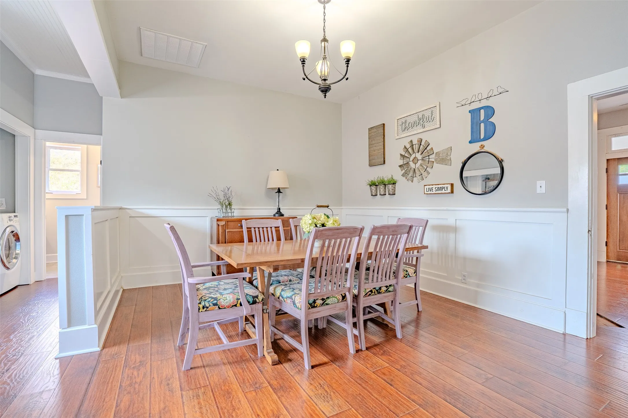 Laminate flooring, half-wall wainscoting, and a built-in chandelier