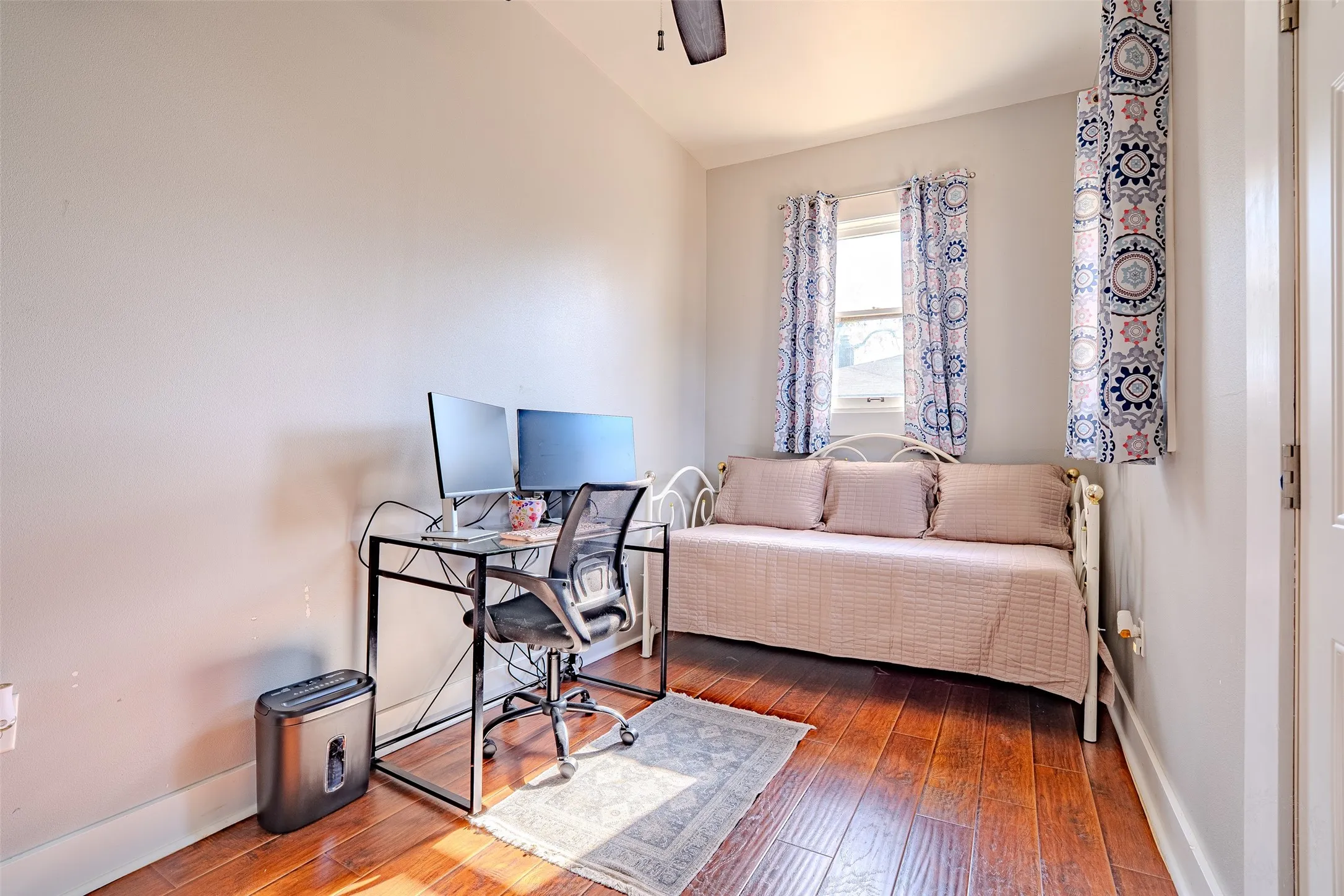 Laminate flooring throughout, with a single window and ceiling fan