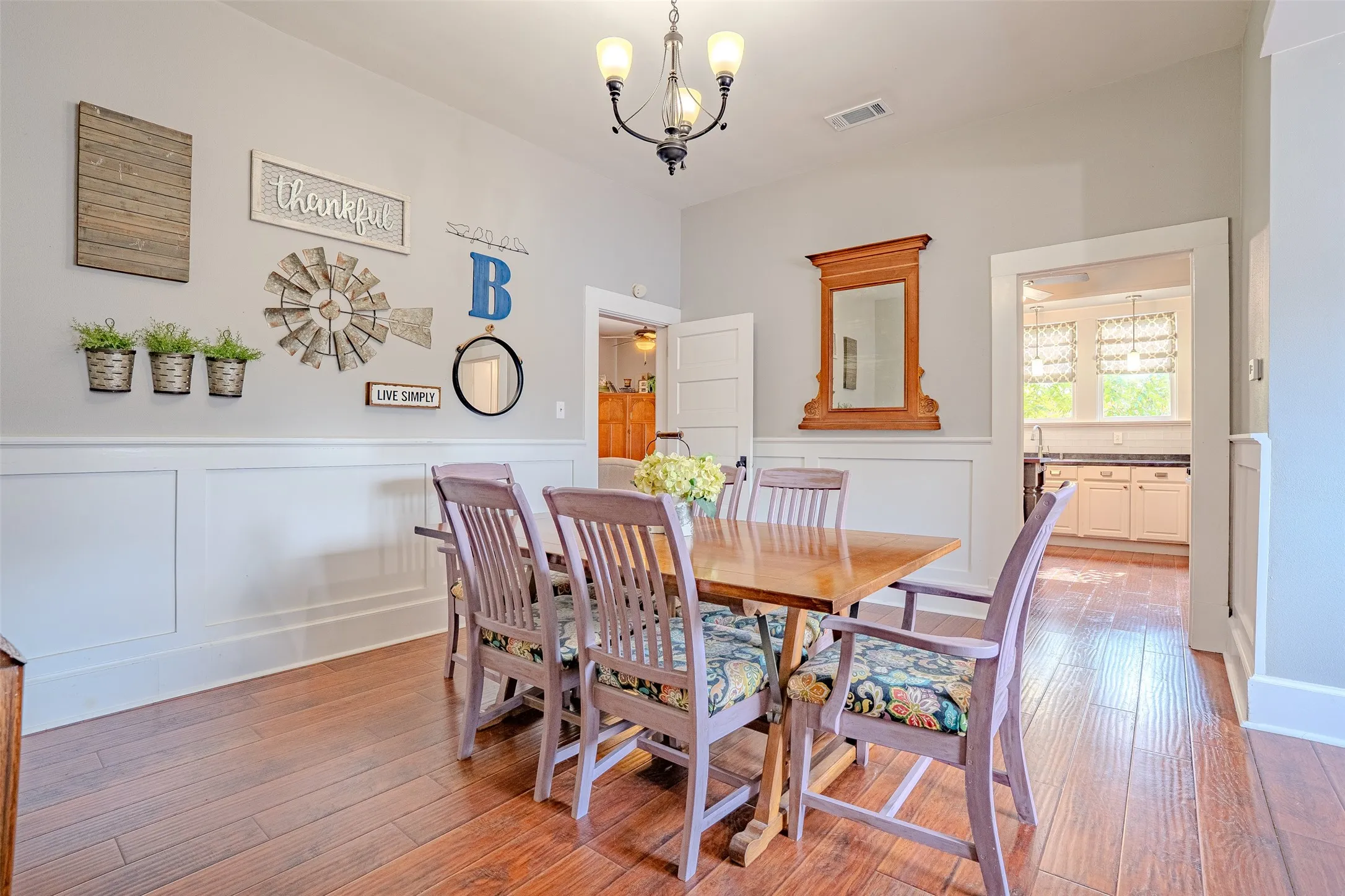 Laminate flooring, wainscoting, and a ceiling-mounted light fixture