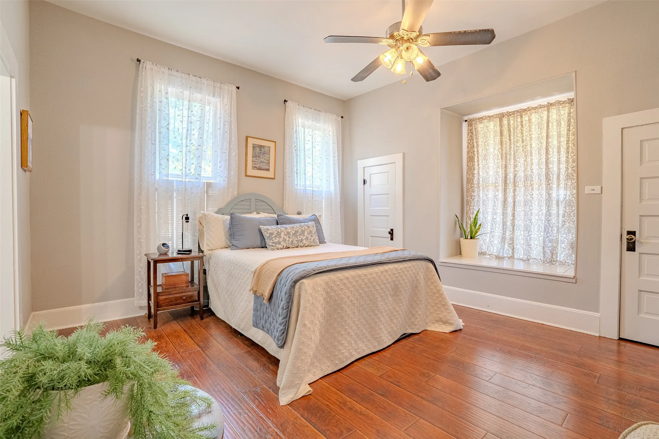 Laminate flooring, recessed window ledge, ceiling fan with integrated lighting, and multiple windows