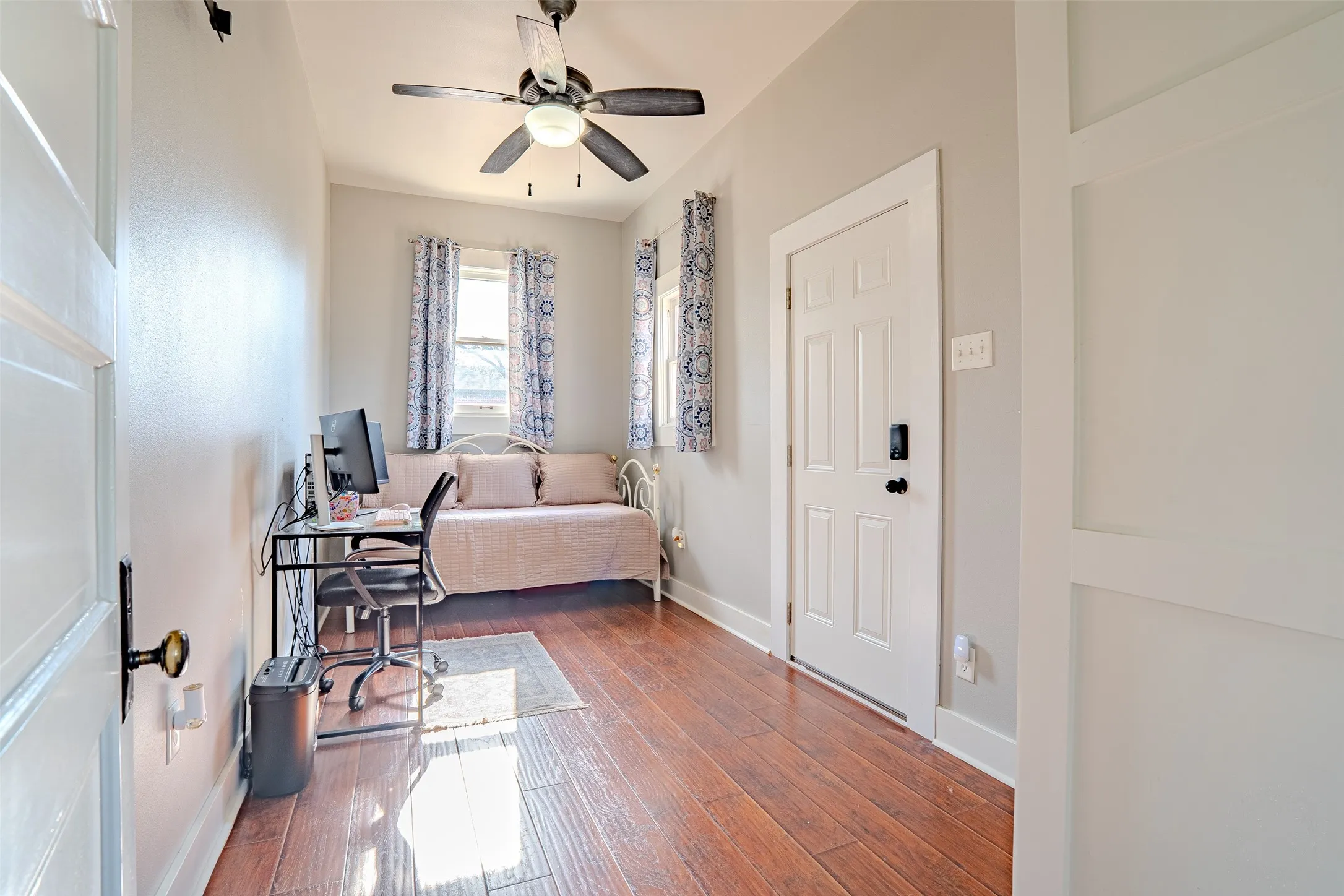 Laminate flooring, painted walls, ceiling fan with integrated lighting, and white interior doors