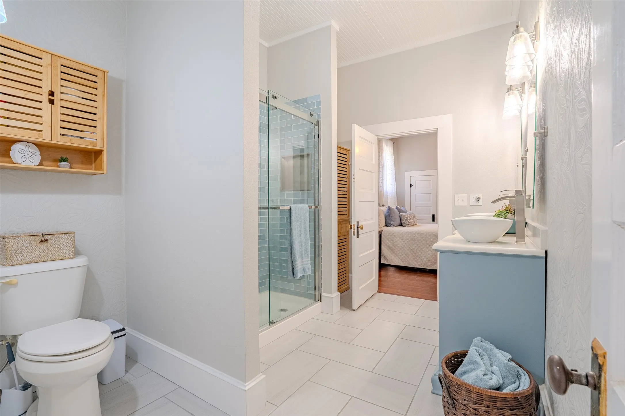 Tiled flooring with a walk-in shower featuring a glass enclosure