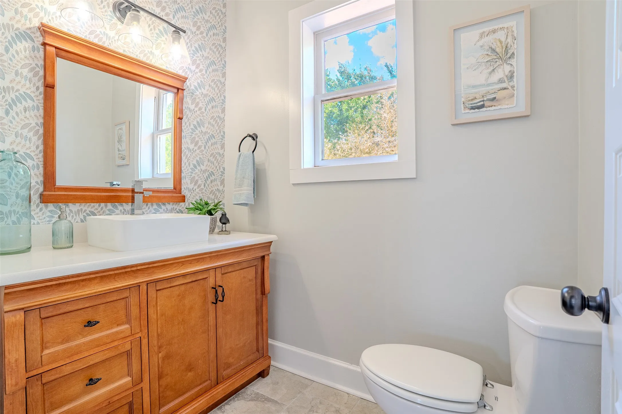 Wood-finish vanity with a white countertop and a vessel sink