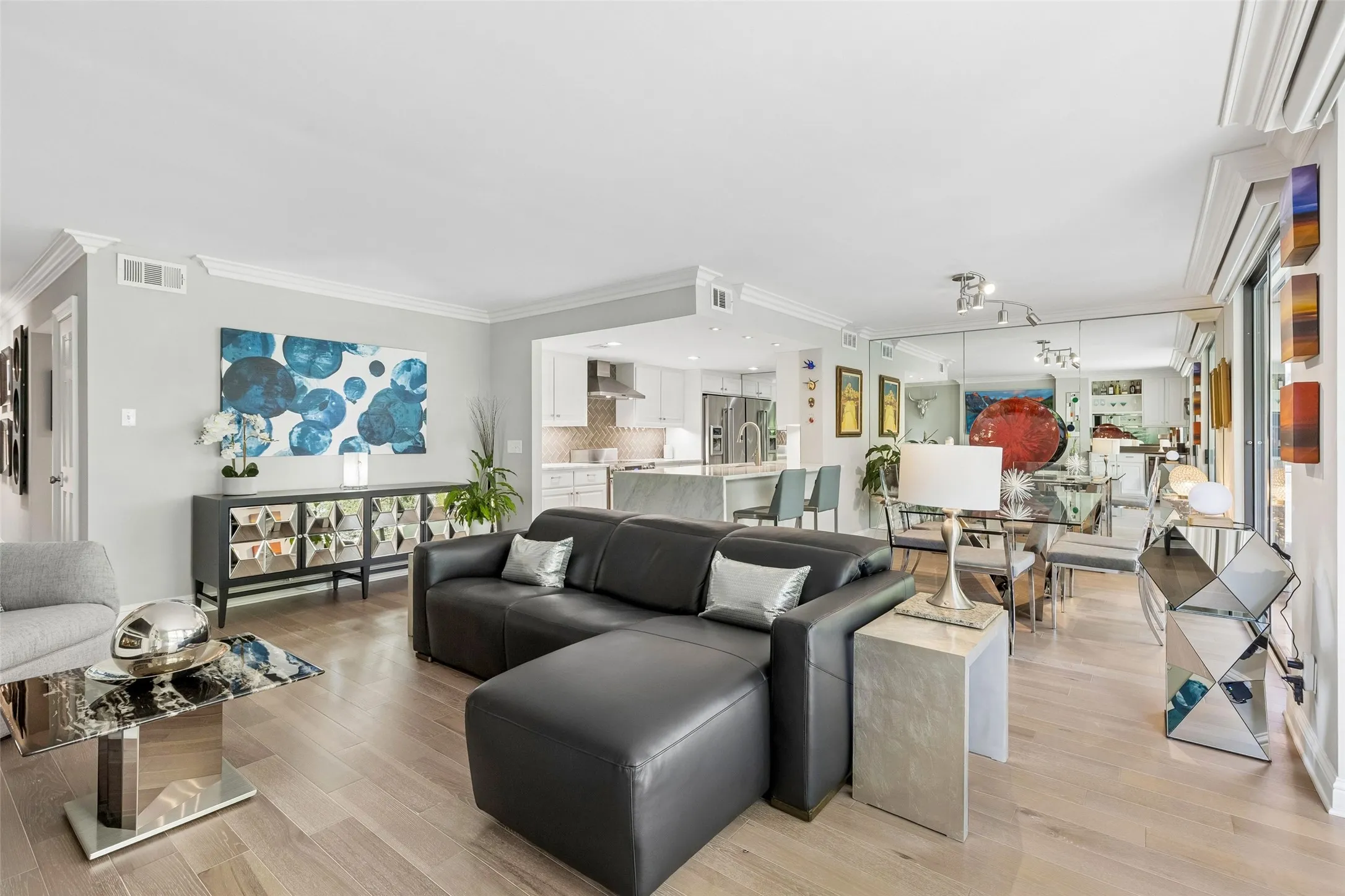 Open concept living area with wood-finish flooring, crown molding, and recessed lighting