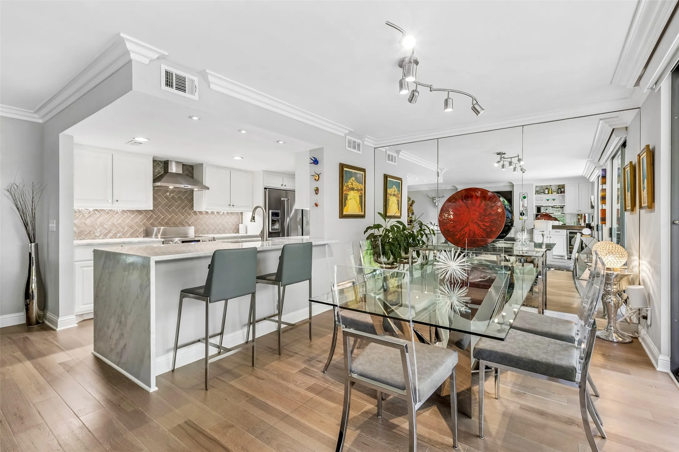 Open-concept living space with wood-finish flooring, crown molding, and recessed lighting