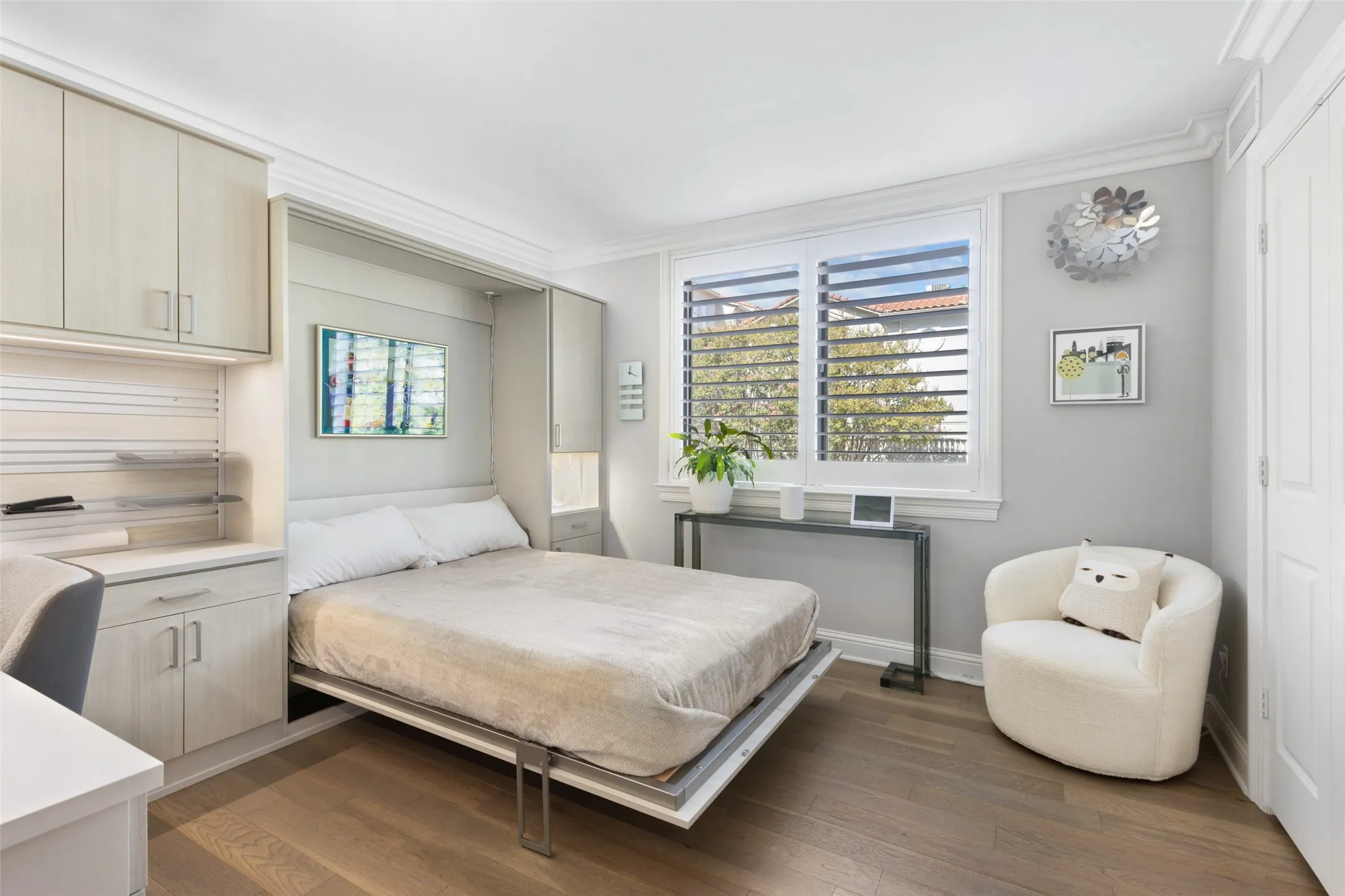 Built-in cabinetry with integrated lighting, wood-finish flooring, and crown molding