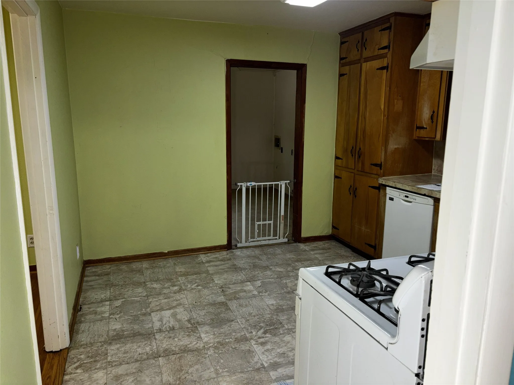 Kitchen featuring wood cabinetry, countertop space, and tile-style flooring