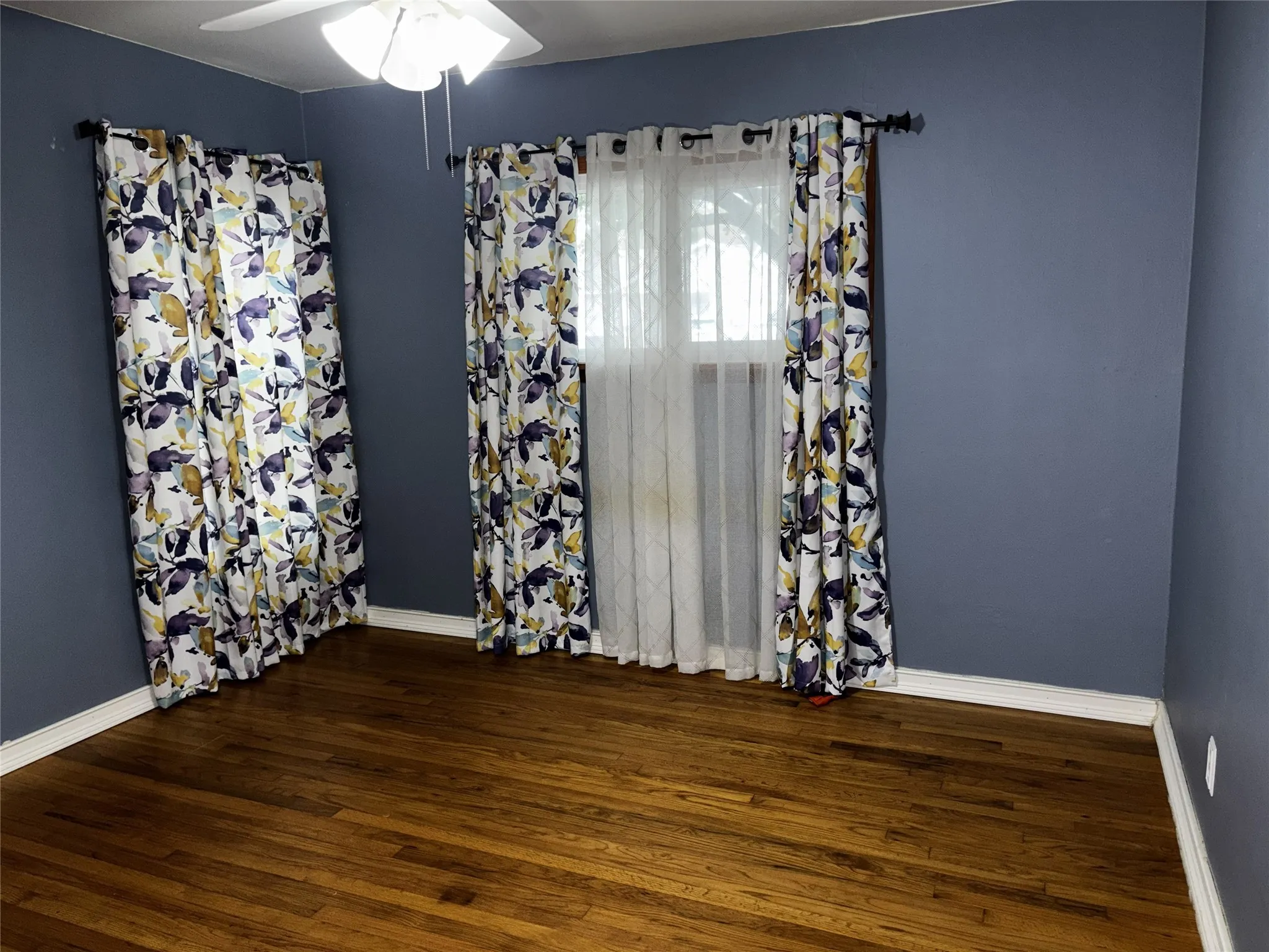 Hardwood flooring and a ceiling fan with integrated lighting