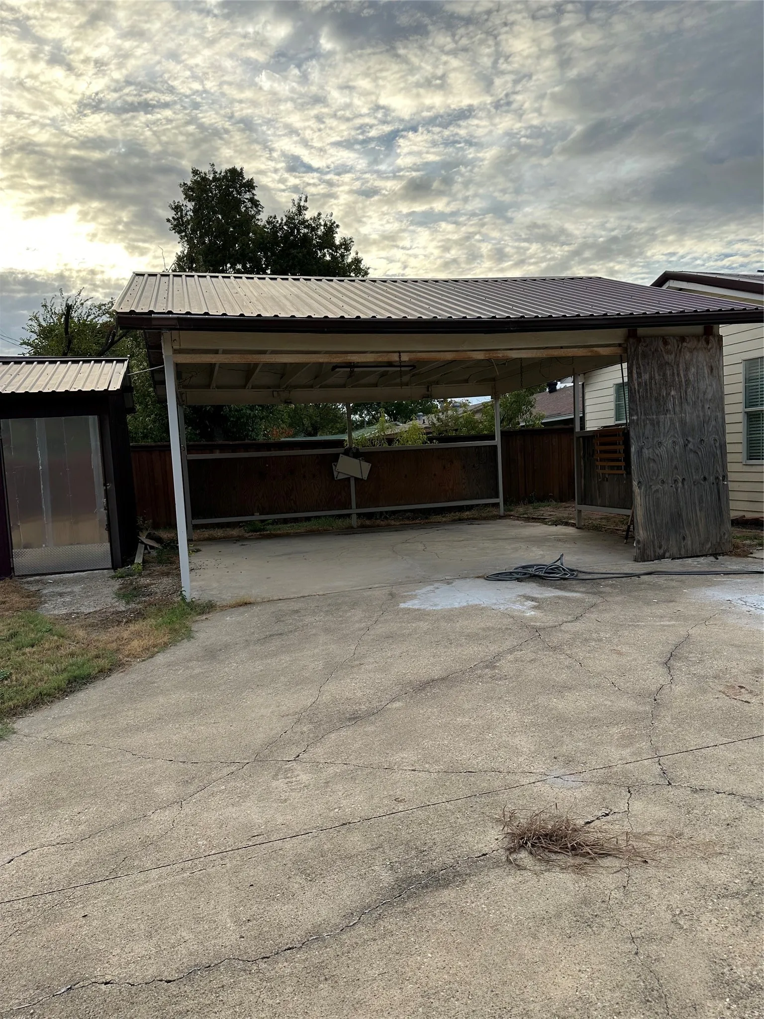 Carport with a metal roof and concrete surfacing