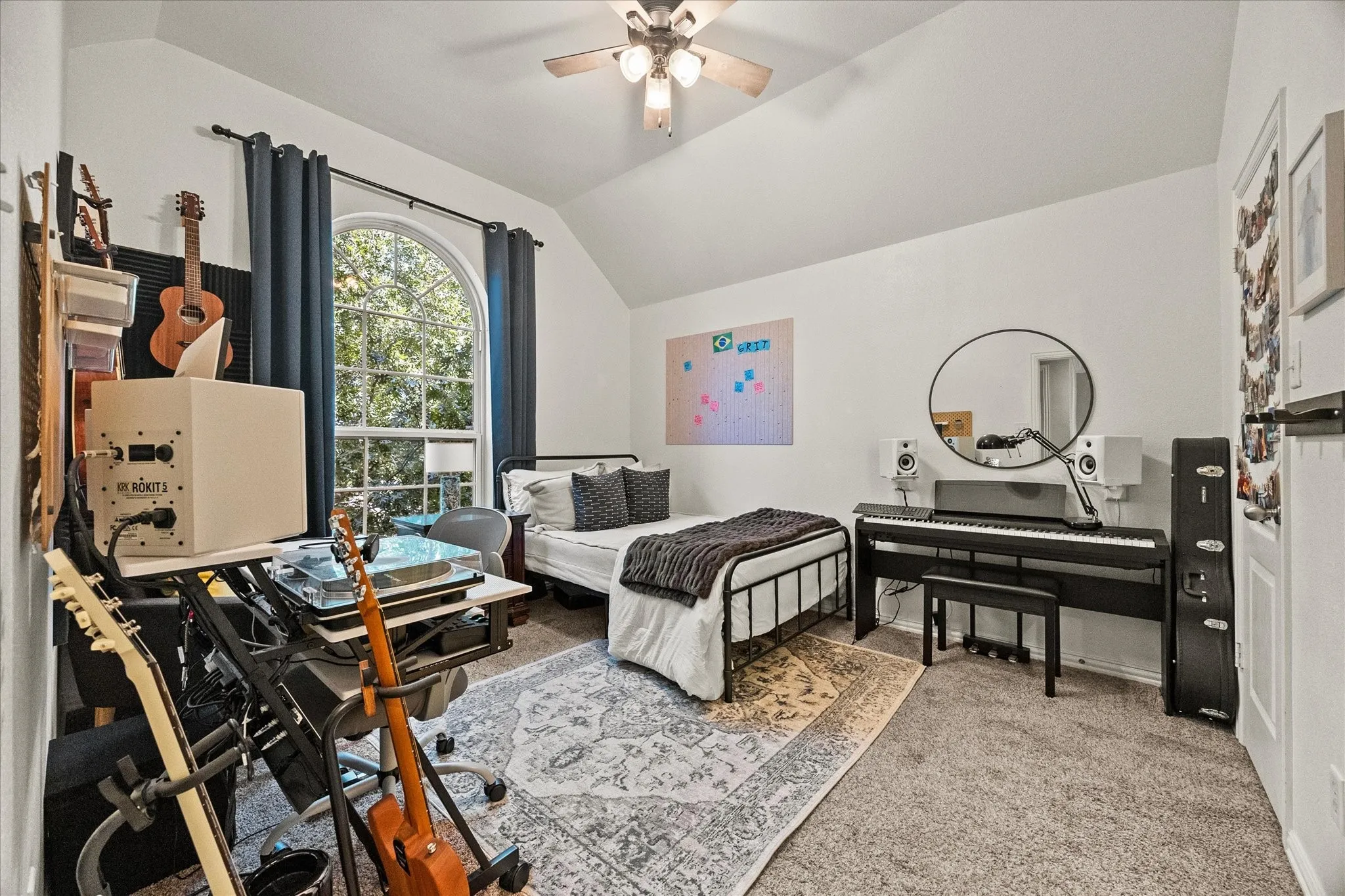 Arched window with exterior tree scenery, recessed lighting, ceiling fan, and carpeted flooring
