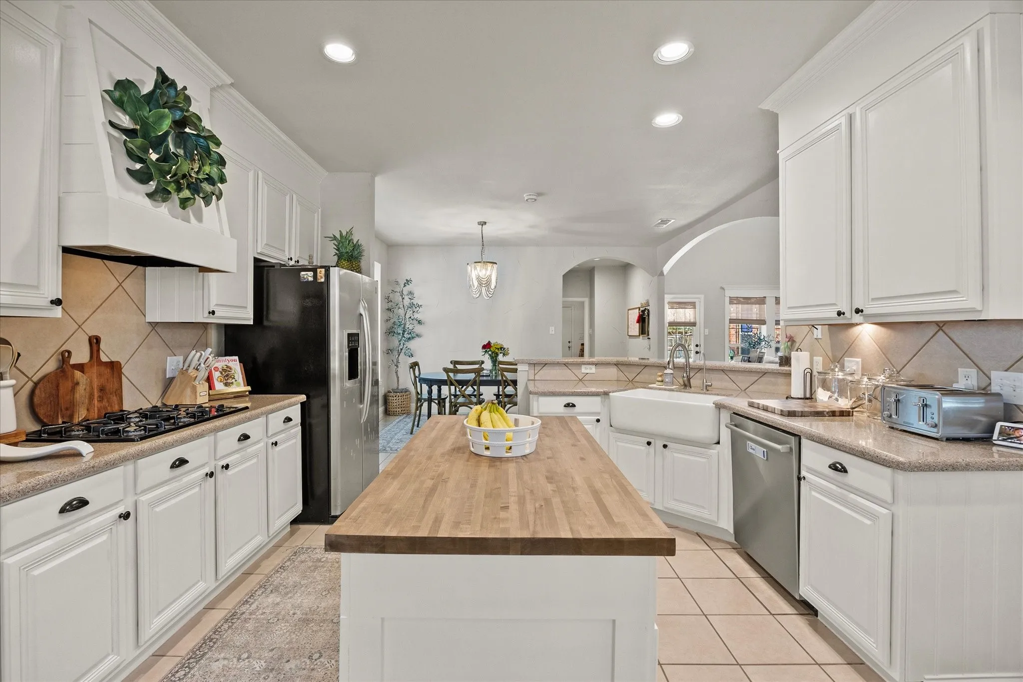 1602 Mapleleaf Drive Wylie, TX 75098 Kitchen featuring white cabinetry, a wood-finish island, a farmhouse sink, stainless steel appliances, and tile flooring