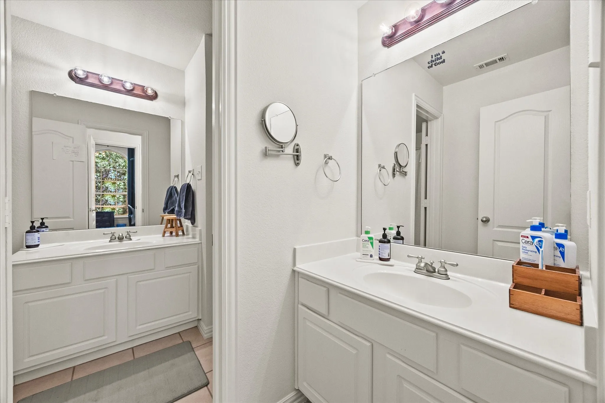 Dual vanity setup with integrated sinks, white cabinetry, and wall-mounted mirrors