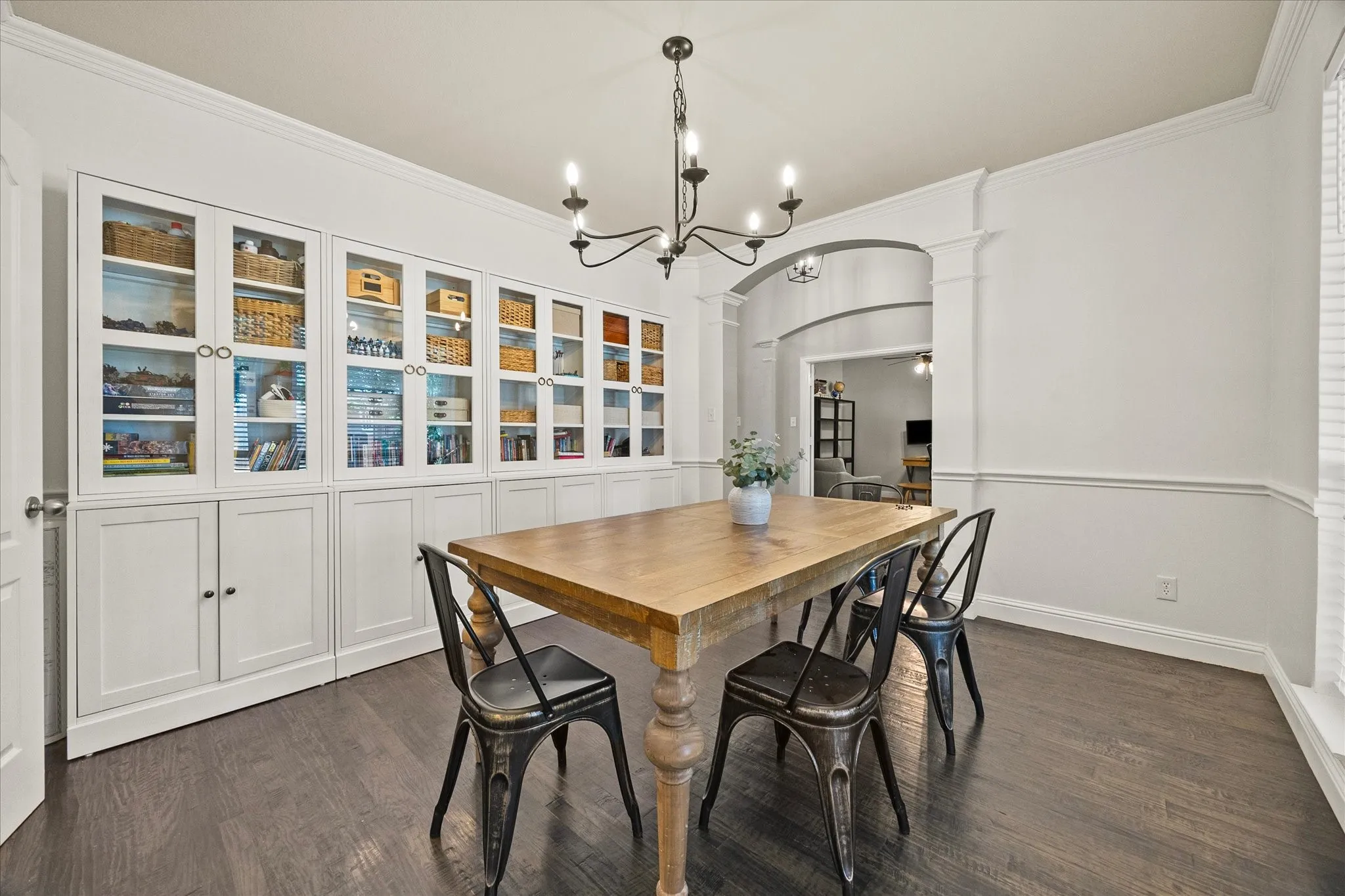 1602 Mapleleaf Drive Wylie, TX 75098 Built-in cabinetry with glass-front uppers and solid lower doors, wood-finish flooring, decorative wall trim, and an archway with columns